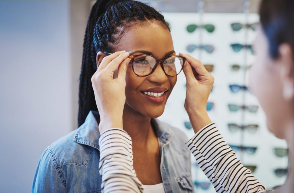 A young woman trying on prescription glasses at the optometrist