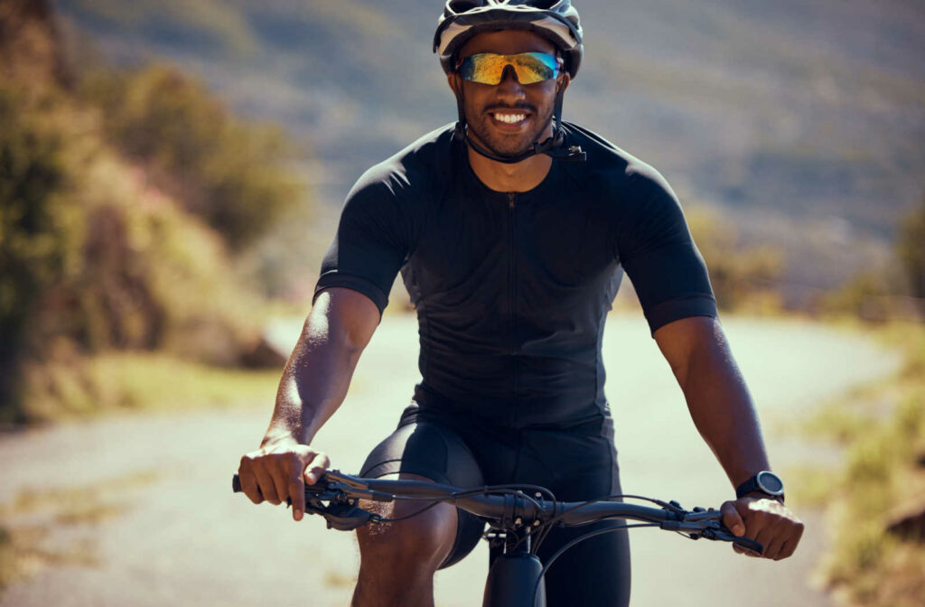 A man riding a mountain bike while wearing sports glasses.